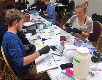 George Gunter and Meghan Drew test water samples in a makeshift lab in a hotel conference room.