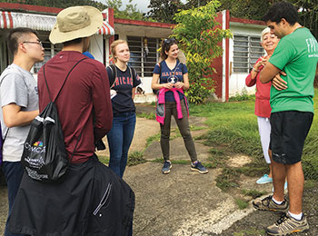 With the help of a translator (far right), students interview  a community member in Orocovis.