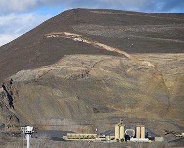 The cracks above the quarry equipment are clearly visible from a distance.