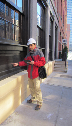 Professor Youssef Hashash indicates the height of the water line from flooding on a building in Manhattan.