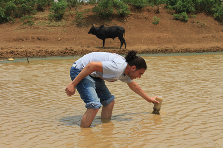 CEE student Abdul Hassaballah collects a sample from a drinking water source near Bondo, Kenya.