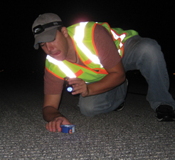 Working at night when the runways are closed, CEE student Josh Green places a test object on a runway.