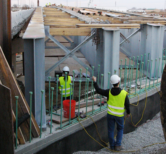 Provided by Larry Fahnestock. University of Illinois at Urbana-Champaign graduate students Sunny Zhou and Gaoyu Liu install strain gauges on X-shaped cross frames at Mattis Avenue Bridge over I-57 in Champaign, Illinois, on Nov. 9, 2020. The bridge over I-57 has integral abutments &mdash; where the girders are encased in concrete at the ends &mdash; whereas the bridge over I-74 has expansion bearings at the ends that allow movement.