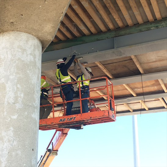 Provided by Larry Fahnestock. Sunny Zhou and Jared Motley, UIUC graduate and undergraduate students, respectively, install strain gauges on a girder at Mattis Avenue Bridge over I-57 in Champaign, Illinois, on Dec. 1, 2020. Construction of the Mattis Avenue bridges over I-57 and I-74 is estimated to be complete by August 2021.