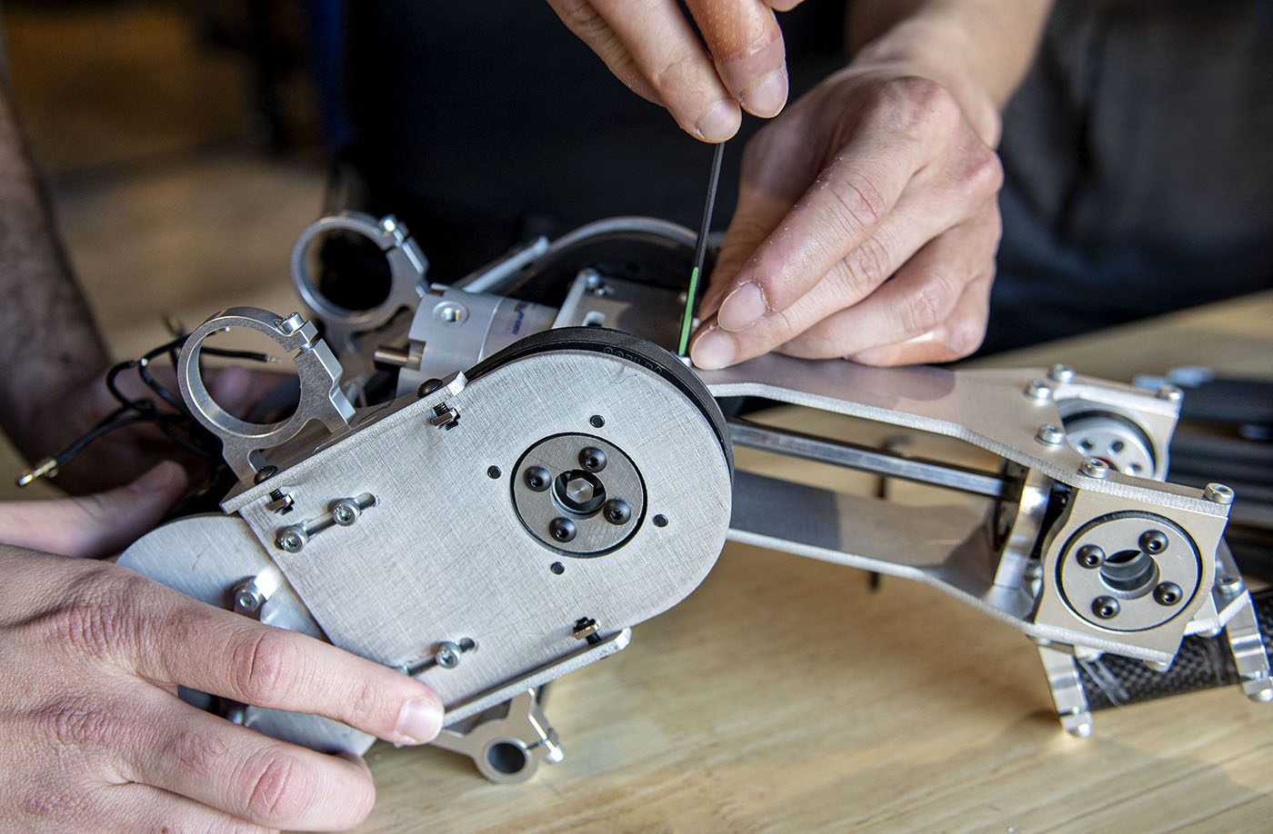 Person tightening screw on robot piece