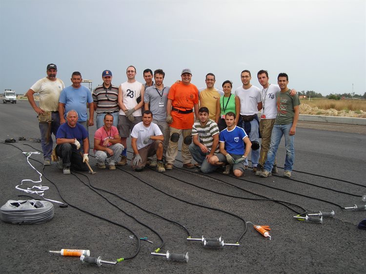 Imad Al-Qadi with University of Cagliari students and researchers at an airport in Italy. They are installing the first instrumentation &mdash; sensors used to monitor pavement response to moving airplanes and the environment &mdash; at a European airport. The shown deflection system was designed by Al-Qadi.