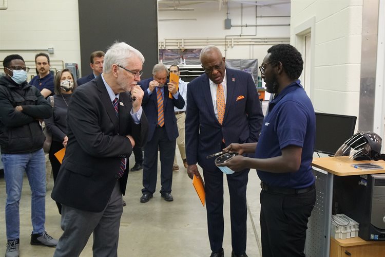 Uthman Mohamed Ali, ICT research engineer, shows President Killeen and Chancellor Jones an asphalt binder sample after ultraviolet testing during the tour of ICT&amp;amp;amp;rsquo;s facilities.