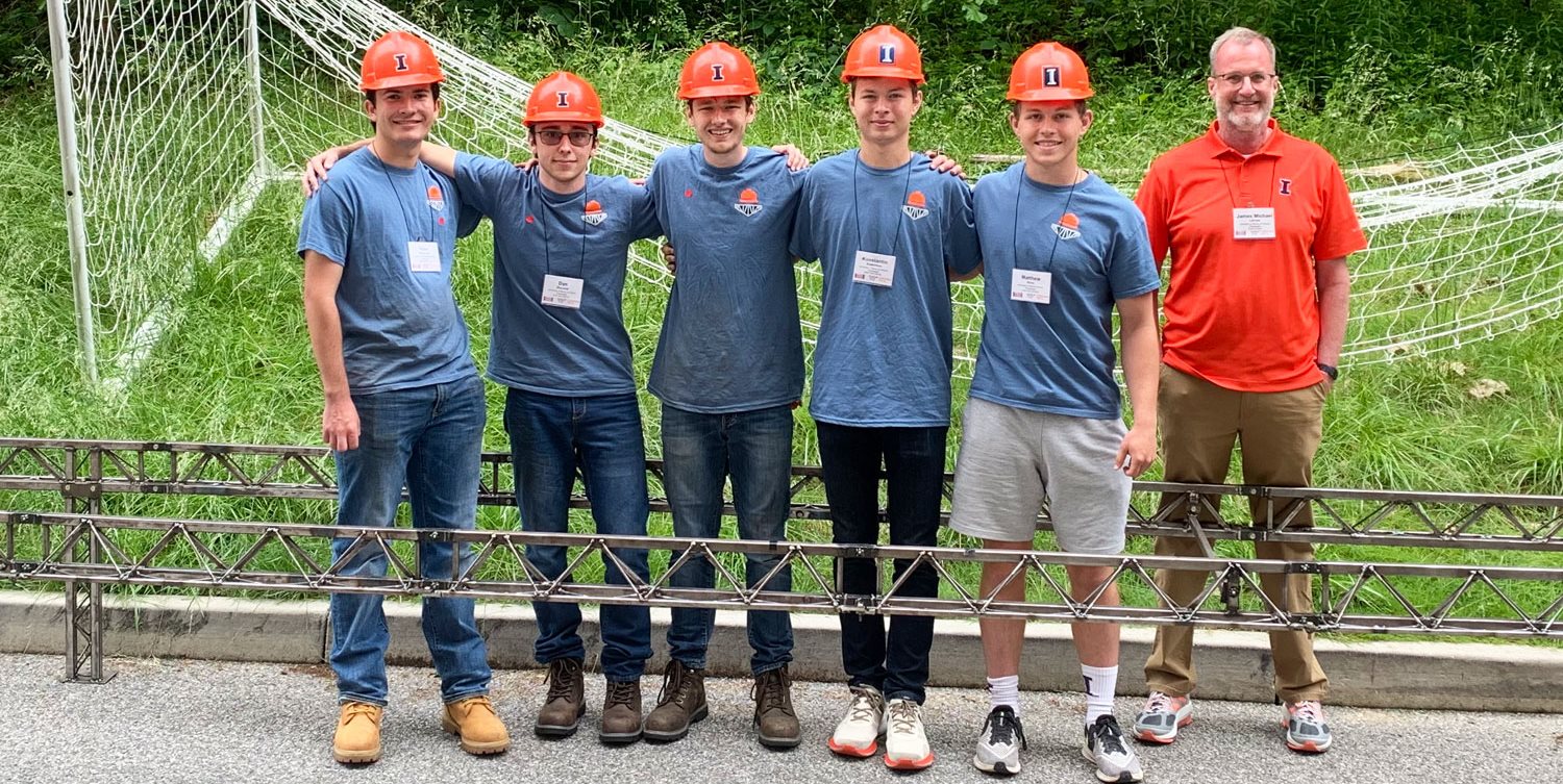 Left to right: UIUC Student Steel Bridge Team members Ryan Hammond, Dan Zhuravel, Matt Groll (BS 22, captain), Konstantin Kotelnikov, and Matt Ross with their bridge and Faculty Adviser Professor Jim LaFave (BS 86, MS 87) at the national SSBC.